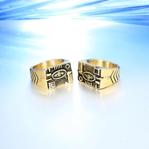 Macro detail of men's gold signet rings featuring industrial tech patterns and gears