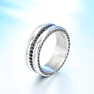 Silver couples ring with black stones and beaded edges on a blue background