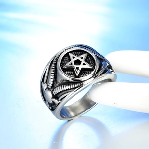 Detailed macro view of retro silver pentagram ring with skull patterns on the side