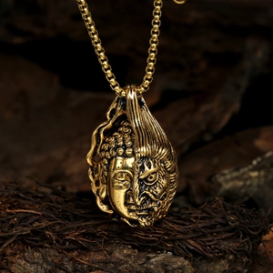 Macro detail of vintage gold steel necklace with Buddha and Demon double-sided pendant