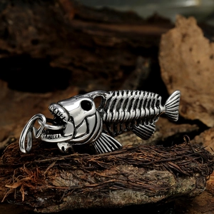 Vintage stainless steel fish bone pendant with hook on dark rustic wood background