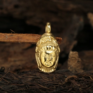 Vue macro d'un pendentif tête de Bouddha doré sur fond en bois avec détails précis
