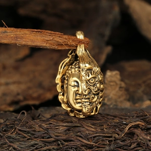 Detailed close-up of vintage titanium steel Buddha and Demon pendant on wood