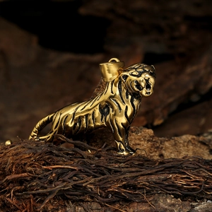 Pendentif tigre en acier inoxydable doré avec rayures noires sur fond bois sombre