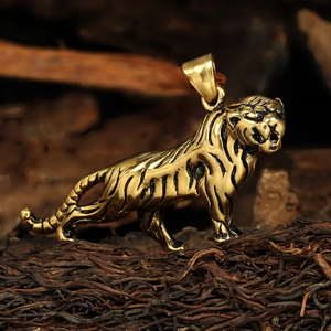 Détail d'un pendentif tigre doré avec gravures précises sur un support en bois