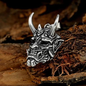 Detailed macro view of vintage stainless steel demon bull pendant on natural wood bark