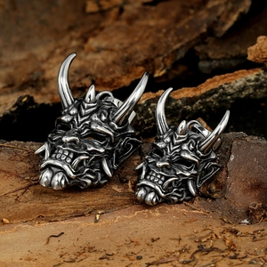 Vintage stainless steel devil bull head pendants in two sizes on a natural wood background