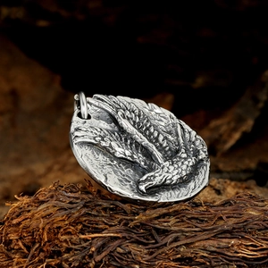Gros plan du pendentif relief aigle rétro avec finition en argent oxydé sur bois