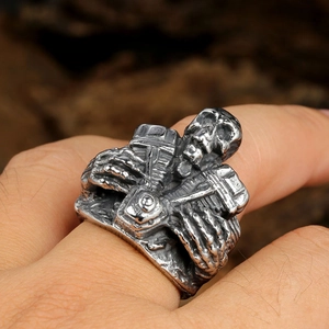 Close-up of retro biker ring featuring skull and V-twin engine in polished titanium steel