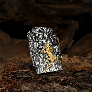 Detailed shot of lizard pendant with rock texture on rustic wooden background