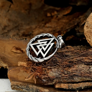 Gros plan du pendentif Valknut en acier inoxydable sur fond d'écorce rustique