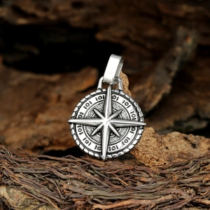 Vintage stainless steel compass pendant necklace with embossed star design on wood