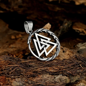 Détail macro du pendentif Valknut argenté avec texture de dragon sur bois vintage