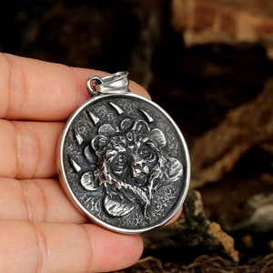 Vintage stainless steel lion head pendant with relief details shown in a lifestyle view