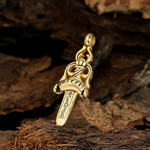 Macro detail of golden sword pendant with soldier engraving on rustic wood background