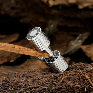 Gros plan du pendentif haltère en argent avec gravure GO FIT sur fond texturé