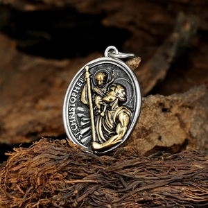 Two-tone St. Christopher pendant on rustic wood background with vintage steel finish