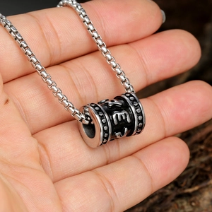 Pendentif cylindre mantra en acier inoxydable rétro sur chaîne box tenue à la main