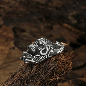 Pendentif tête de mort gothique en argent avec gravures sur fond de bois rustique