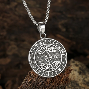 Silver Viking Tree of Life pendant necklace with Norse runes on a rustic wood background