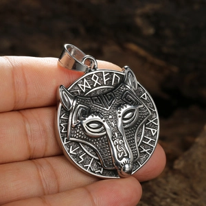Vintage stainless steel wolf head pendant with Nordic runes shown in hand