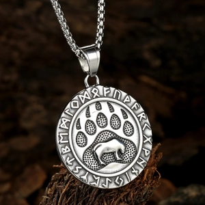 Viking bear paw pendant necklace with runic circle on textured bark background