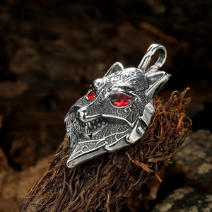 Nordic Viking wolf head pendant with red eyes on textured wood, silver stainless steel
