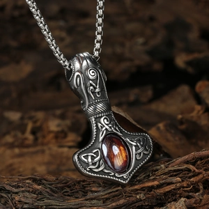 Macro detail of Mjolnir pendant with amber stone on rustic wood background