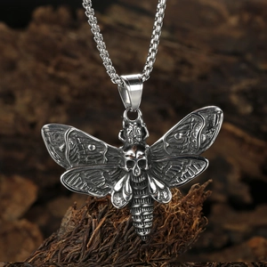 Gothic moth skull pendant necklace in silver stainless steel on dark wood texture