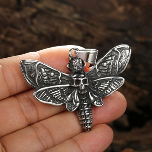 Gothic skull moth pendant in vintage stainless steel finish held in hand for size