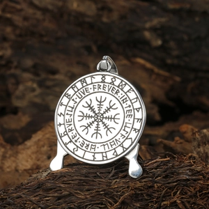 Pendentif boussole Viking Vegvisir argenté avec runes sur fond de bois rustique