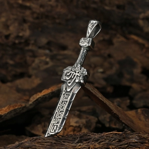 Vintage stainless steel sword pendant necklace with intricate engraved patterns on dark wood