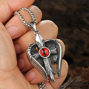 Gros plan détaillé du pendentif croix gothique avec œil rouge et ailes de chauve-souris