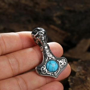 Detailed close-up of Viking Mjolnir pendant with skull motif and blue turquoise stone