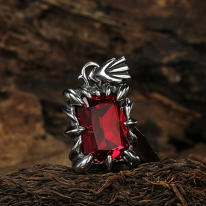 Collier griffe gothique en argent avec gemme rouge rectangulaire sur fond en bois sombre