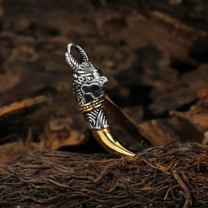 Vintage stainless steel dragon tooth necklace with gold accents on a rustic wood background
