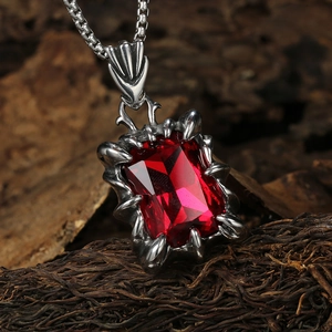 Détail d'un pendentif griffe gothique en argent avec pierre rouge rectangulaire et chaîne