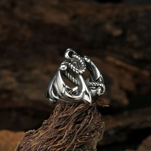 Detailed close-up of retro silver anchor ring with rope design on rustic wood base