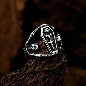Vue détaillée d'une bague cercueil gothique avec croix et crânes sur fond rustique