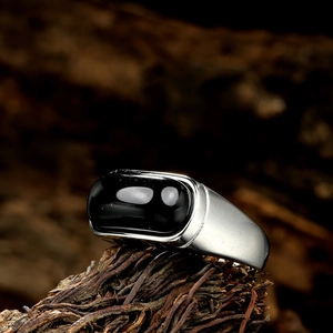 Macro detail of men's vintage stainless steel ring with rectangular black onyx stone