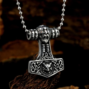 Nordic Viking Mjolnir pendant with lion head and runes on rustic wood background