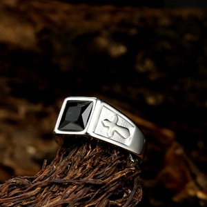 Close-up of vintage stainless steel signet ring with black gemstone and cross engraving