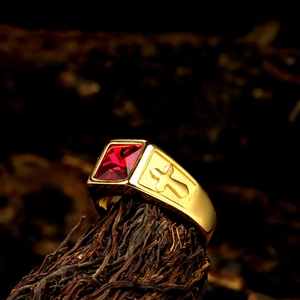 Detail of a vintage titanium steel ring with a red gemstone and cross engraving