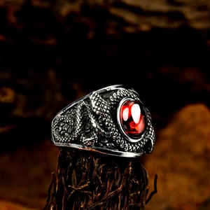 Vue macro d'une bague serpent gothique avec pierre rouge sur fond de bois rustique