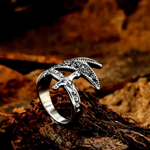 Macro detail of retro steel ring featuring a cross sword design and black zircons