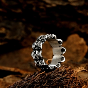 Vintage silver skull ring with gothic punk design displayed on a natural wood texture