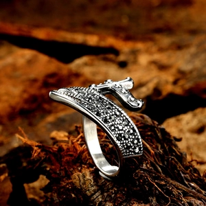Vintage stainless steel ring with black rhinestones on a rustic wooden base background