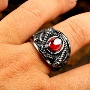 Gros plan d'une bague écailles de dragon rétro avec pierre rouge ovale au doigt