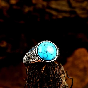Gros plan d'une bague vintage pour homme avec turquoise ronde et gravures ornementales