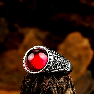 Vue macro d'une bague punk vintage avec pierre rouge ovale et reliefs ciselés